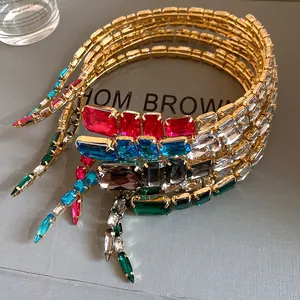 Macro detail of multi-layered gold choker with colorful square rhinestones