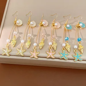 Elegant gold-tone drop earrings featuring colorful starfish shell charms and pearls