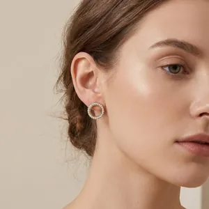 Sfeervolle close-up van elegante vergulde titaanstaal oorbellen met micro-pave kristallen