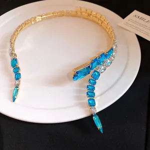 Detailed view of luxury gold-tone choker featuring vibrant blue and clear square crystals