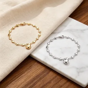 Exquisite Detailansicht gold- und silberfarbener Herzkettenarmbänder mit Anhängern