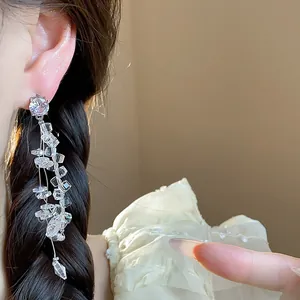 Close-up of elegant silver tassel earrings with sparkling zircon and glass stones