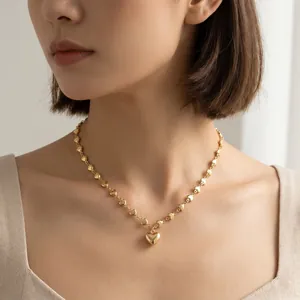 Detailansicht einer eleganten 18-Karat-Goldkette mit Herzanhänger an einem Model