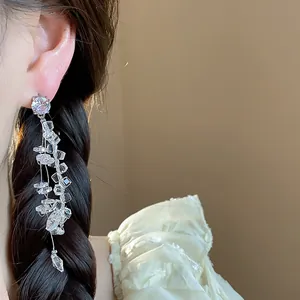Close-up detail of silver needle zircon tassel earrings with sparkling glass water droplets