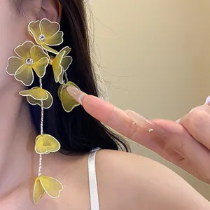 Detail shot of elegant yellow mesh flower tassel earrings with sparkling rhinestone accents