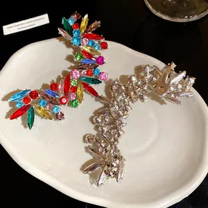 Dettaglio ravvicinato di lussuosi orecchini a clip con strass colorati davanti e dietro