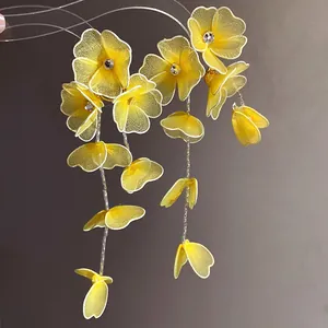 Detailed view of yellow silk mesh floral earrings featuring clear center rhinestones