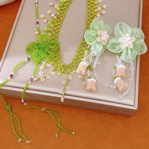 Detail shot of green beaded forest-style necklace and matching chiffon flower earrings.