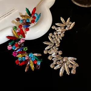 Vista dettagliata di lussuosi ear cuff in strass con design curvo e irregolare.
