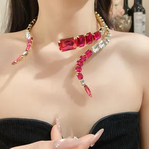Detail view of a wrap-around snake style necklace with red and clear rectangular stones.