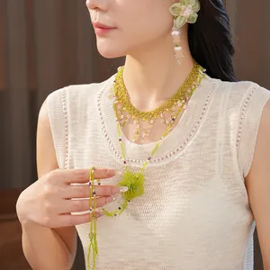 Model wearing forest style beaded necklace with green flower and matching earring