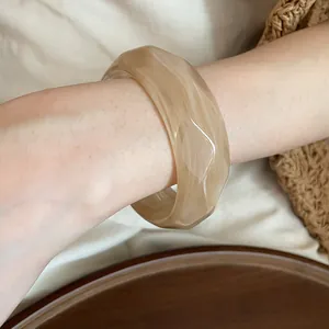 Primo piano di un bracciale rigido in acrilico sfaccettato con elegante trama marmorizzata