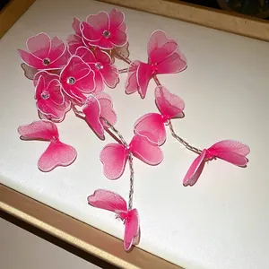 Close-up detail of pink silk mesh flower earrings featuring rhinestones and long tassels