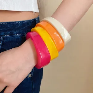 Vibrant colorful marbled resin bangles set featuring unique curved geometric design.