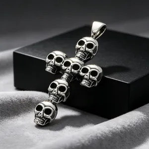 Detalle de un colgante de cruz con calaveras de estilo punk gótico en acero inoxidable.