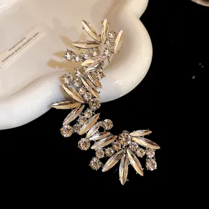 Primo piano di lussuoso earcuff irregolare con strass scintillanti e design a ramo