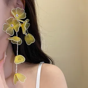 Macro view of yellow mesh flower tassel earrings featuring sparkling rhinestone centers.