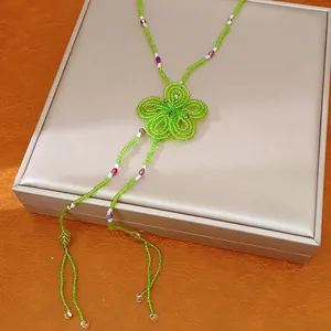 Detailed view of handmade green beaded flower necklace in bohemian forest style