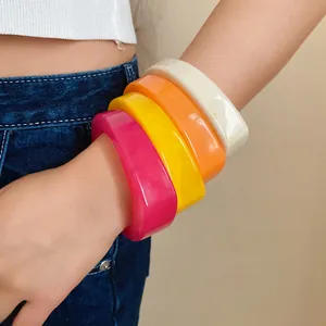 Detailed view of colorful resin bangles set on wrist for women's fashion jewelry