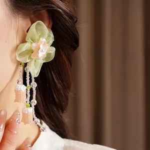 Detailed shot of Bohemian style chiffon flower earring with beaded tassels and resin core