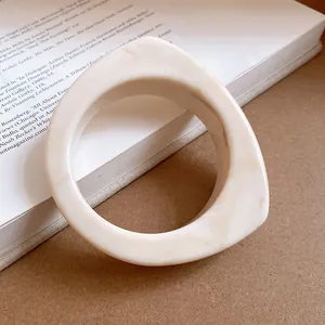 Macro view showing the smooth marble texture and curved design of the resin bangle