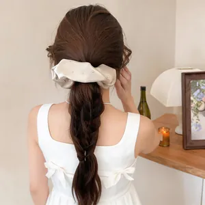Vista posteriore di una donna che indossa un fermaglio per capelli in tessuto champagne e strass