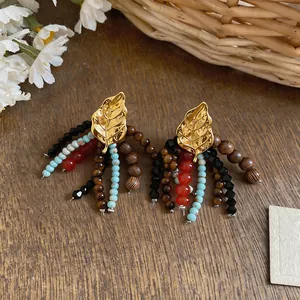 Detailed view of vintage leaf earrings with colorful wooden and glass bead tassels