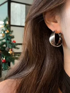 Close-up of elegant silver layered hoop earrings worn on ear