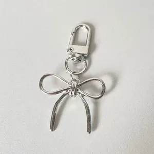 Fashionable silver alloy bow keychain and bag charm with a minimalist design