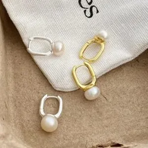 Detail view of minimalist S999 silver and gold plated pearl drop hoop earrings for women