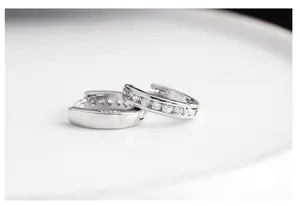 Macro detail of 925 sterling silver hoop earrings with inlaid sparkling crystals