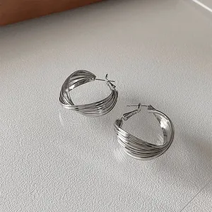Detailed macro shot of elegant silver multi-layered twisted hoop earrings for women.