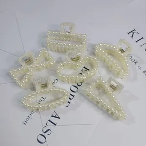 Close-up of elegant white pearl hair claw clips in various geometric shapes on white background