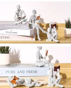 Close-up of creative reading woman resin figurine with modern text pattern decor.