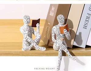Detailed shot of creative resin figurines covered in text patterns reading books