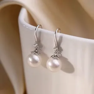 Detailed view of elegant silver pearl drop earrings featuring zircon flower accents.