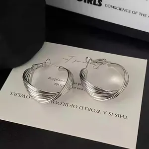 Detailed macro view of elegant silver multi-layered twisted hoop earrings for women