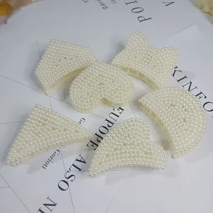 Detailed macro view of various elegant pearl-encrusted hair claw clips in different shapes.