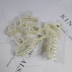 Close-up of elegant white pearl hair claw clips in various shapes for elegant updos