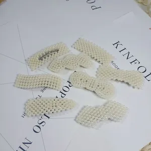 Variety of elegant white pearl hair clips arranged on a white background
