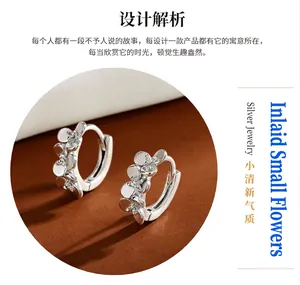 Close-up of S999 silver hoop earrings featuring polished flower petals and sparkling zircons.