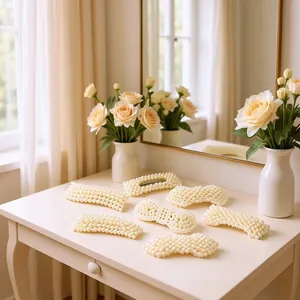 Elegant handmade pearl hair clips set displayed on a vanity table with flowers.