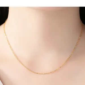 Detailed view of a minimalist thin gold-plated necklace chain worn on a model's neck