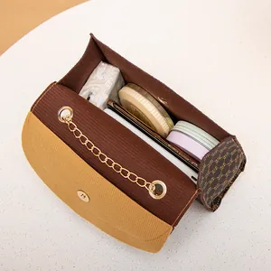 Stylish small chain shoulder bag with vintage monogram pattern showing interior capacity