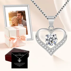 Close-up of silver heart necklace with zircon pendant and romantic gift packaging.