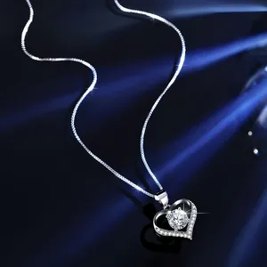 Close-up of heart-shaped silver necklace with sparkling central cubic zirconia stone.