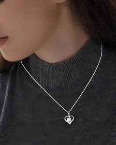 Close-up view of S925 sterling silver heart necklace with zircon on model's neck.