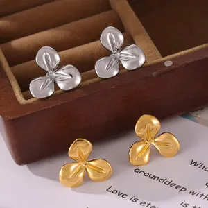 Detailed view of silver and gold stainless steel three-petal flower stud earrings