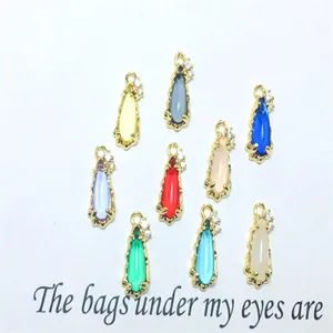 Macro view of colorful teardrop glass pendants with zircon-set copper edging details