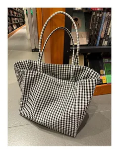 Minimalist black and white checkered tote bag with large capacity in bookstore setting